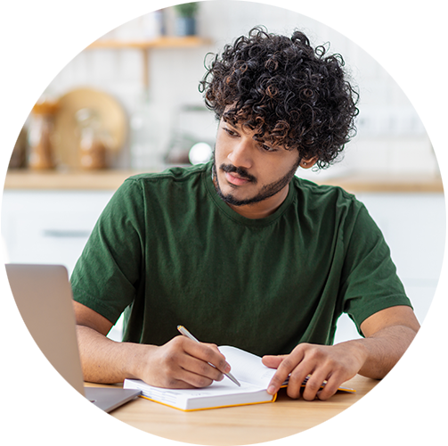 A person wearing headphones studying on a laptop