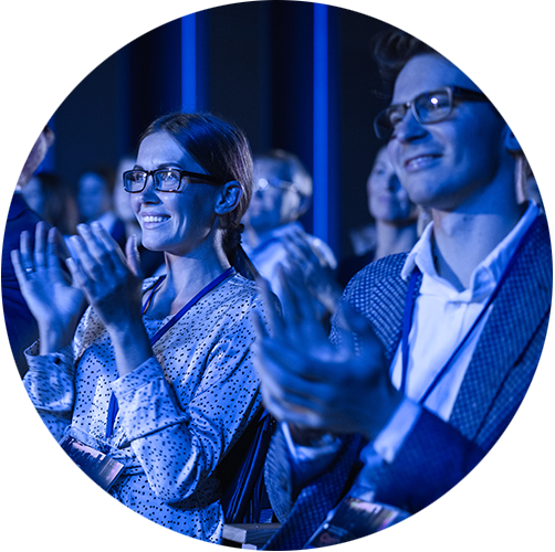 Two peple facing forwrd at an event clapping