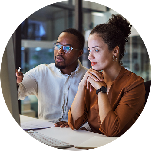 Two people looking at a screen. It looks like one is pointing explaining something to the other