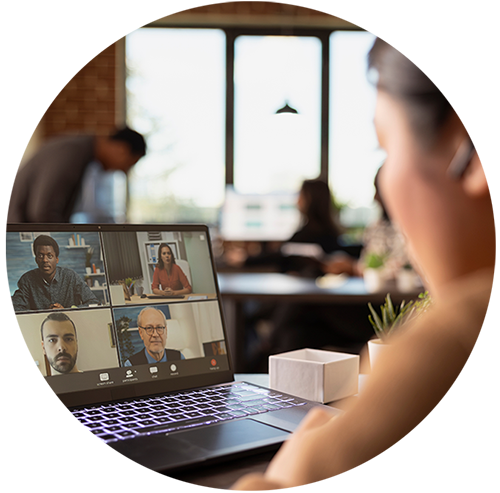 A person sitting looking at a video teams call on their laptop in an office space